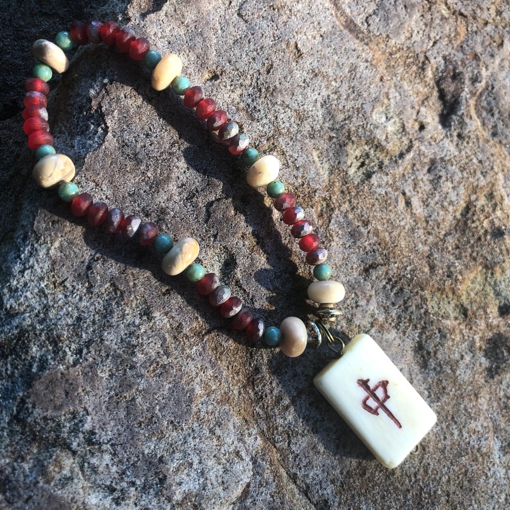 Beaded bracelet with Ivory Colored Chinese Symbol Charm